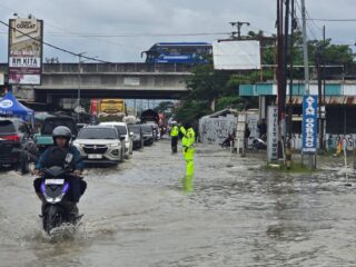 Petugas Lakukan Pengaturan Lalu Lintas di Tengah Genangan Air Jalur Pejagan–Ketanggungan